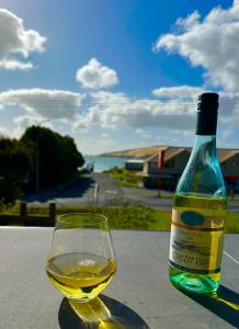 a bottle of white wine sitting next to a glass at Beach view studio 337 in Omapere