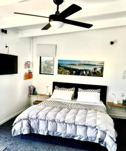 a bedroom with a bed with a ceiling fan at Beach view studio 337 in Omapere +31 photos