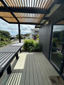 a wooden deck with a bench on a house at Beach view studio 337 in Omapere