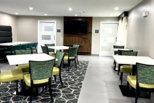 una sala da pranzo con tavoli e sedie e una TV a schermo piatto di Wingate by Wyndham Jackson a Jackson