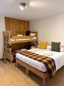 ein Schlafzimmer mit zwei Etagenbetten und einer Leiter in der Unterkunft Hotel Ambassador Bormio in Bormio