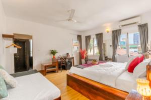 a bedroom with two beds and a desk at Emeraldgems Residence - Deplicate in Phumĭ Prêk Chrey