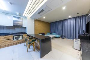 uma cozinha com um balcão, uma mesa e cadeiras em Arieti A em Gimhae