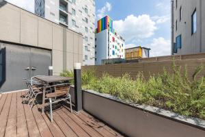 um deque de madeira com uma mesa e cadeiras numa varanda em Arieti A em Gimhae