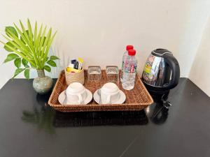 een mand met bekers en flessen water op een tafel bij SOMA Villa in Phumĭ Réach Born