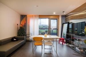 uma sala de estar com um sofá, uma mesa e cadeiras em Arieti A em Gimhae