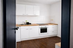 a kitchen with white cabinets and a sink at Worker Place Emmerich in Emmerich
