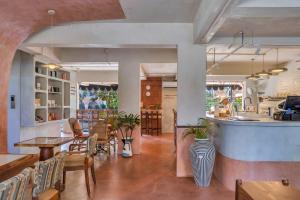 a restaurant with tables and chairs and a counter at Unseen Boutique Hotel, Assagao in Assagao