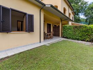 a patio of a house with a grass yard at Gorgeous Holiday Home in Sorano with Swimming Pool in Sorano