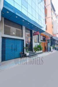 a store with a blue garage door on a street at Olivia Hotels - Delhi Airport in New Delhi