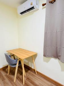 a small table and a chair in a room at 79Hotel Rayong in Ban Hua Phrong