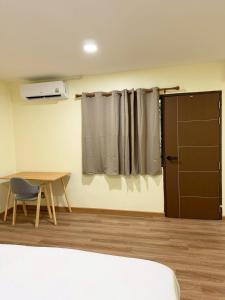 a room with a table and a chair and a window at 79Hotel Rayong in Ban Hua Phrong