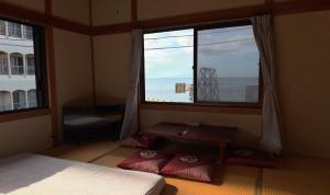 a bedroom with a bed and a large window at 白浜の宿梅 別館 in Shirahama