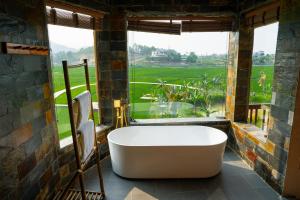 a bath tub in a room with a large window at Diều Sóc Sơn in Sóc Sơn +23 photos
