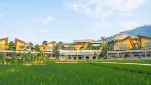 a resort with a large green field and buildings at Diều Sóc Sơn in Sóc Sơn