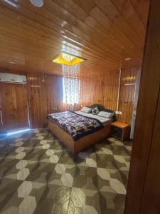 Un dormitorio con una cama en una habitación de madera. en Shyam home stay URBAN Cafe, en Nārkanda