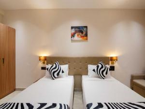 Giường trong phòng chung tại Palette Hotel by CheckIn Pune, MIDC Chinchwad +57 ảnh