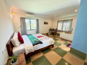 een slaapkamer met een bed en een geruite vloer bij SOMA Villa in Phumĭ Réach Born