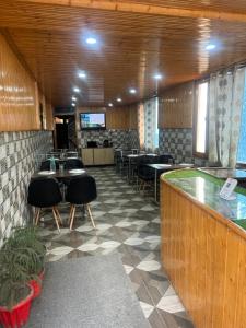 Un restaurante con mesas y sillas y un bar. en Shyam home stay URBAN Cafe, en Nārkanda 9 fotos más