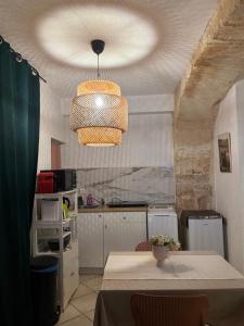 Una cocina con una mesa y una lámpara de araña. en Centre ville, en Tarascon