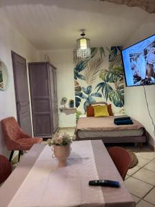 una habitación con una cama y una mesa con flores. en Centre ville, en Tarascon