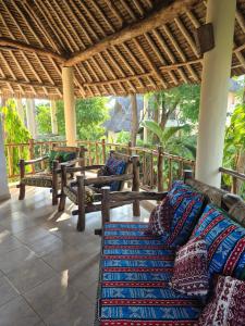 een veranda met banken en kussens op een terras bij Petasha Bustani Villas Diani with pool and parking in Galu