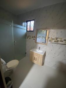 un bagno con lavandino, WC e specchio di La Ureña House a La Ureña