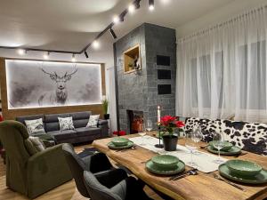 a dining room with a table and a living room at Csuszka Vendégház MÁTRA in Mátraszentimre