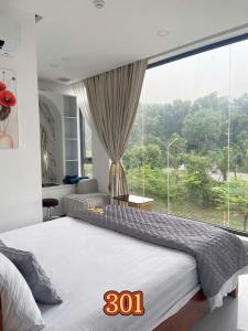 a bedroom with a large bed with a large window at Khách sạn Nữ Vương in Xom Ông Linh