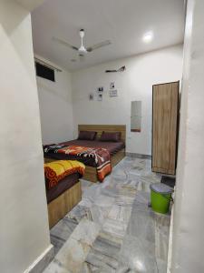 two beds in a room with a tiled floor at Param Dham in Vrindāvan