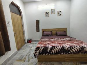 a bedroom with a bed with a wooden frame and a door at Param Dham in Vrindāvan
