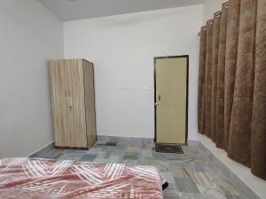 a room with a bed and a door in it at Param Dham in Vrindāvan +4 photos