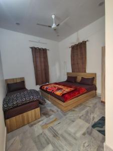 a bedroom with two beds and a ceiling at Param Dham in Vrindāvan