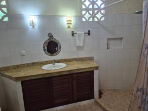 een badkamer met een wastafel en een spiegel bij Petasha Bustani Villas Diani with pool and parking in Galu +19 foto's