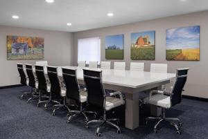 a conference room with a white table and chairs at Baymont by Wyndham Davenport in Davenport