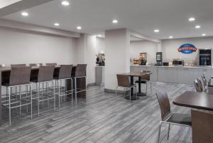 a restaurant with a bar with chairs and tables at Baymont by Wyndham Davenport in Davenport