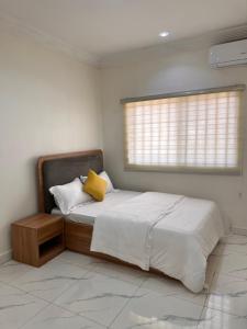 a bedroom with a bed with a yellow pillow on it at Apo Luxe 3-Bedroom Apartment in Garki