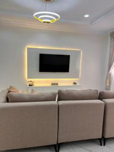 a living room with a couch and a flat screen tv at Apo Luxe 3-Bedroom Apartment in Garki