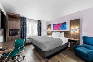 a hotel room with a bed and a desk and a chair at Quality Inn - Denton in Denton