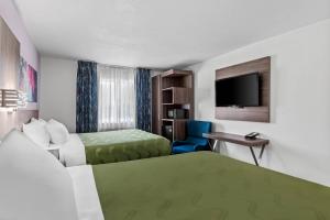 a hotel room with two beds and a flat screen tv at Quality Inn - Denton in Denton +33 photos