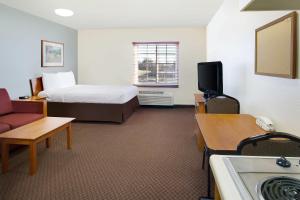 WoodSpring Suites Baton Rouge Airline Highway في باتون روج: غرفة فندق بها سرير وتلفزيون