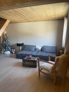 a living room with a blue couch and a christmas tree at Appartement avec vue panoramique in La Celle-sous-Gouzon