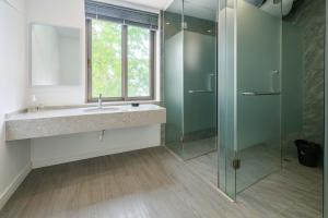 een badkamer met een wastafel en een glazen douche bij Tianya No.7 Homestay in Sanya +16 foto's