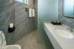 een badkamer met een wastafel en een toilet bij Tianya No.7 Homestay in Sanya