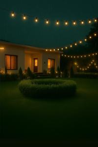 FīrozābādThe RB's Farm的夜晚，一栋房子上方挂着一串彩灯。