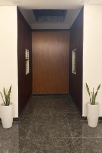 FīrozābādThe RB's Farm的建筑中两棵盆栽植物的走廊