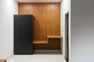 a closet with a black cabinet and a wooden door at The RB's Farm in Fīrozābād