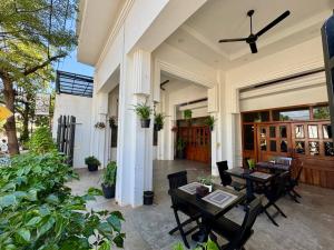 een patio met tafels en stoelen op een huis bij SOMA Villa in Phumĭ Réach Born