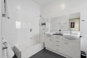 a white bathroom with two sinks and a tub at Poets View - 3 Bedroom House in West Hobart +44 photos