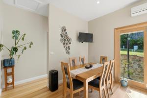 a dining room with a table and chairs at Poets View - 3 Bedroom House in West Hobart